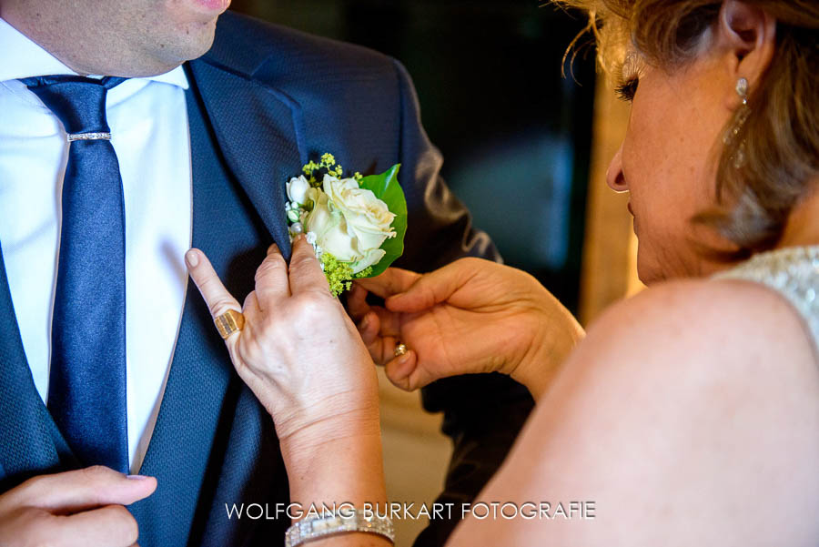 Hochzeitsfotograf aus München in Kitzbühel, Anstecken der Blume am Revers des Bräutigams