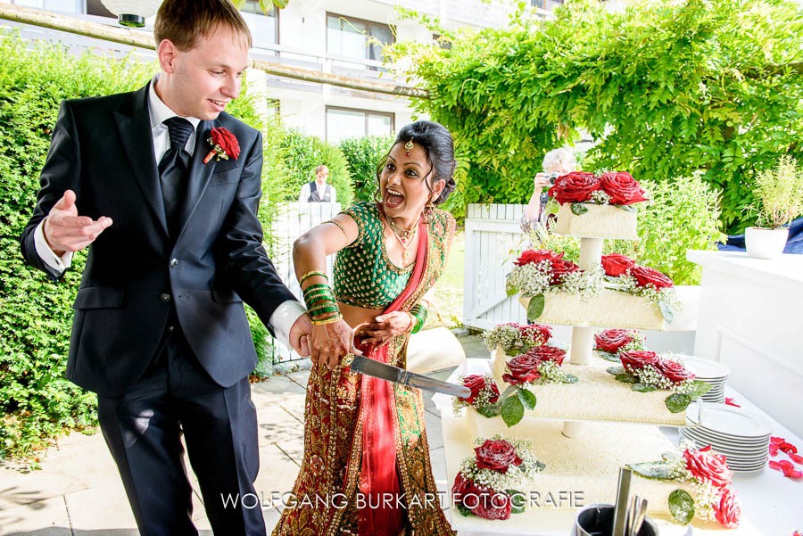 Hochzeit Fotograf München, Brautpaar beim Anschneiden der Hochzeitstorte
