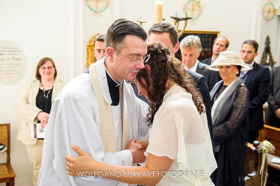 Hochzeit Fotograf Erding bei München, Pfarrer umarmt Braut