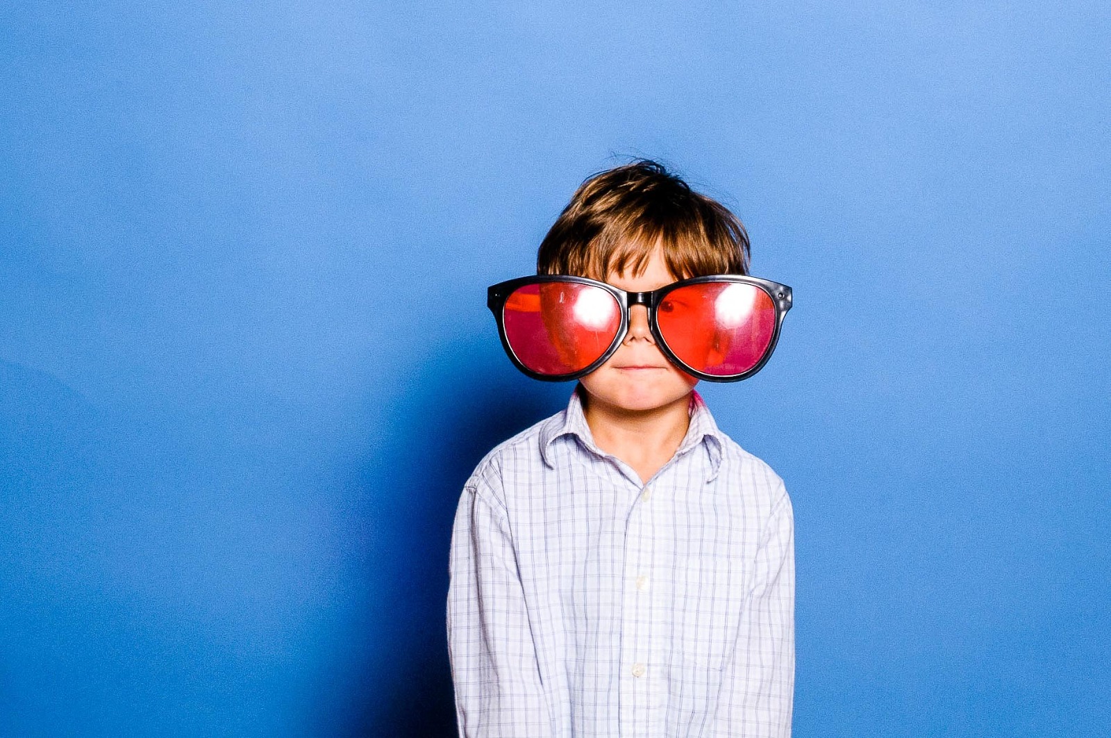 Hochzeits-Fotografie München, Kind mit Riesenbrille vor der Fotobox