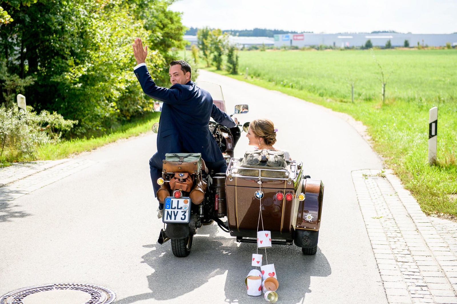 Fotograf München Hochzeit, Brautpaar auf Motorrad mit Seitenwagen und just married Blechdosen