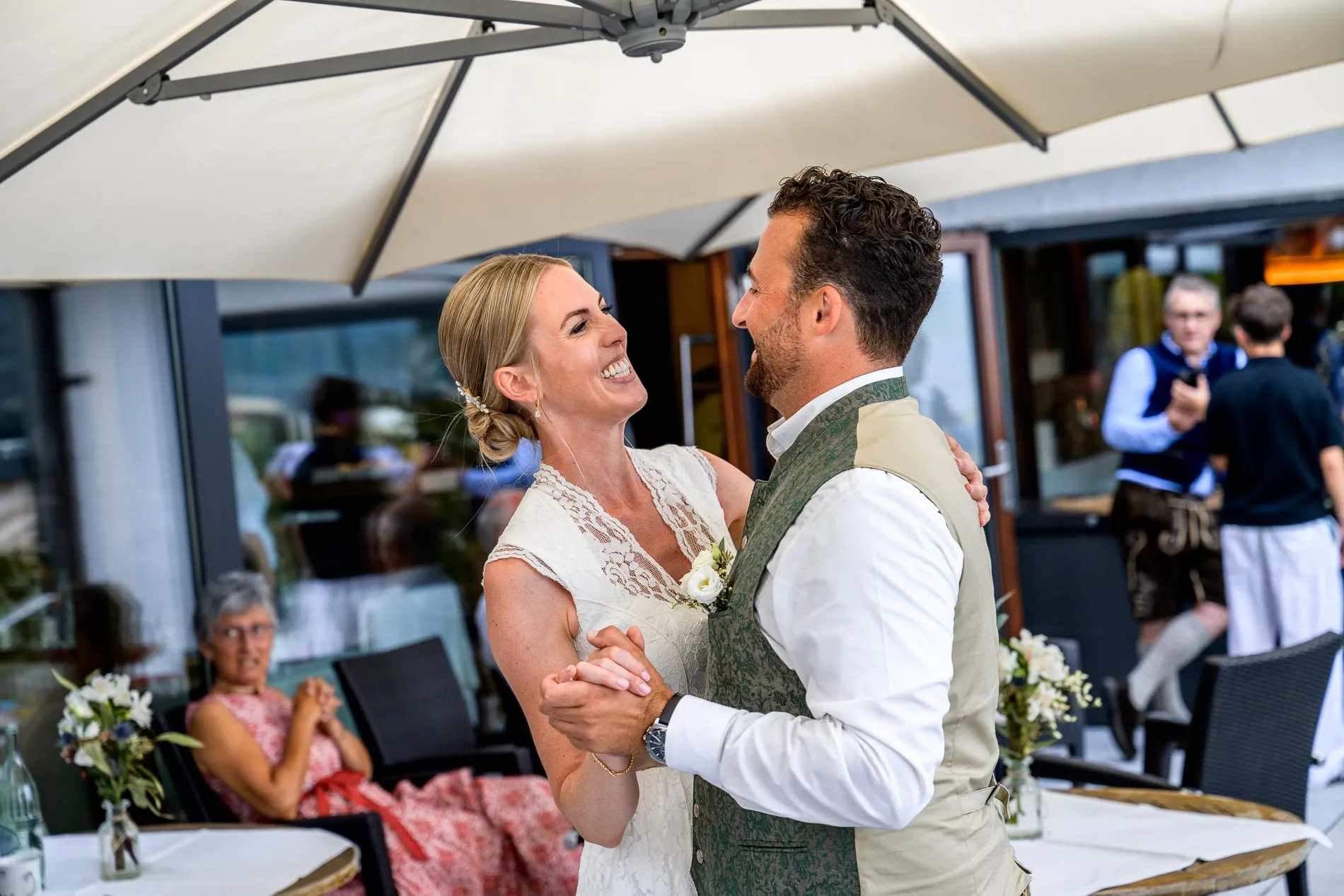 Tanzendes Brautpaar bei einer Hochzeitsfeier im Freien, fröhliche Stimmung, Hochzeitsfotografen-Reportage.